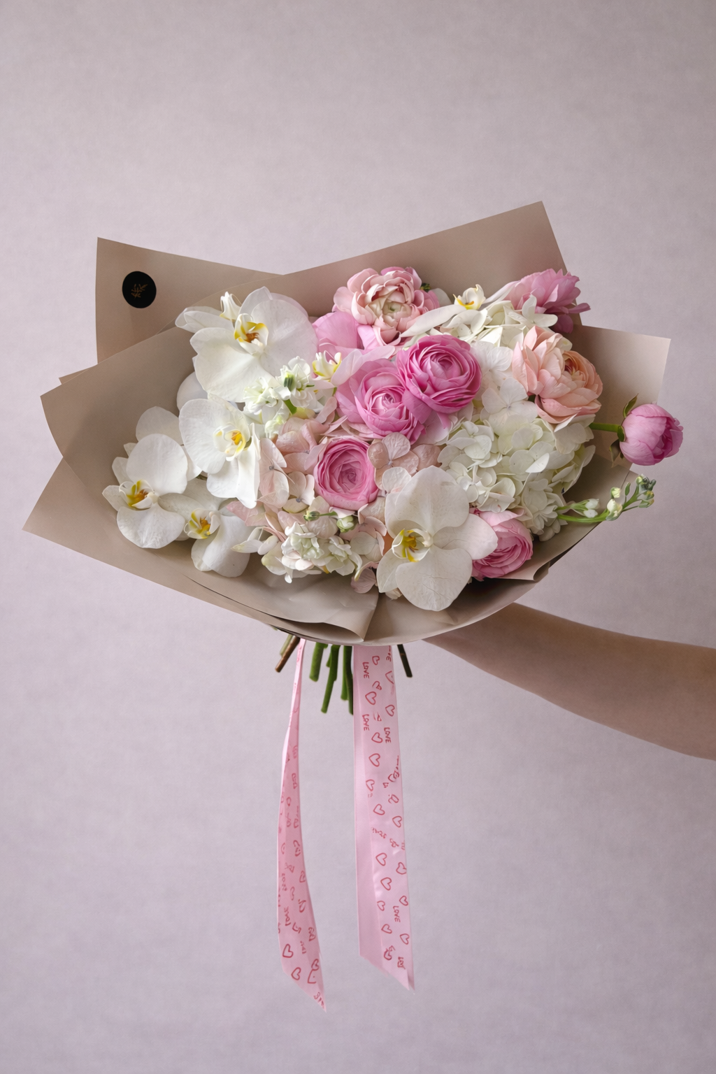 Hermoso atado de flores rosas, ranúnculos, orquídeas para san valentin