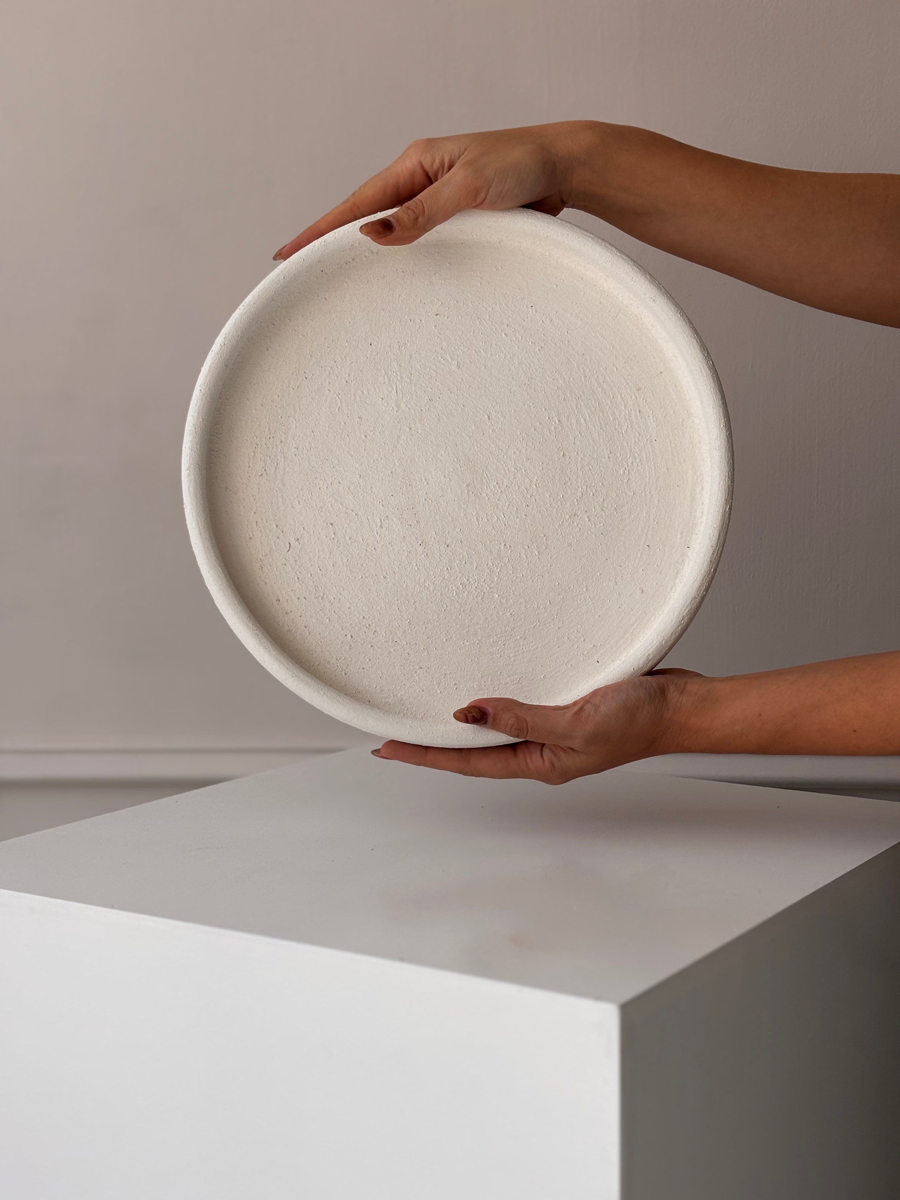 Bandeja decorativa de barro artesanal en color blanco, estilo minimalista, disponible en 30 y 40 cm para centros de mesa y decoración moderna.
