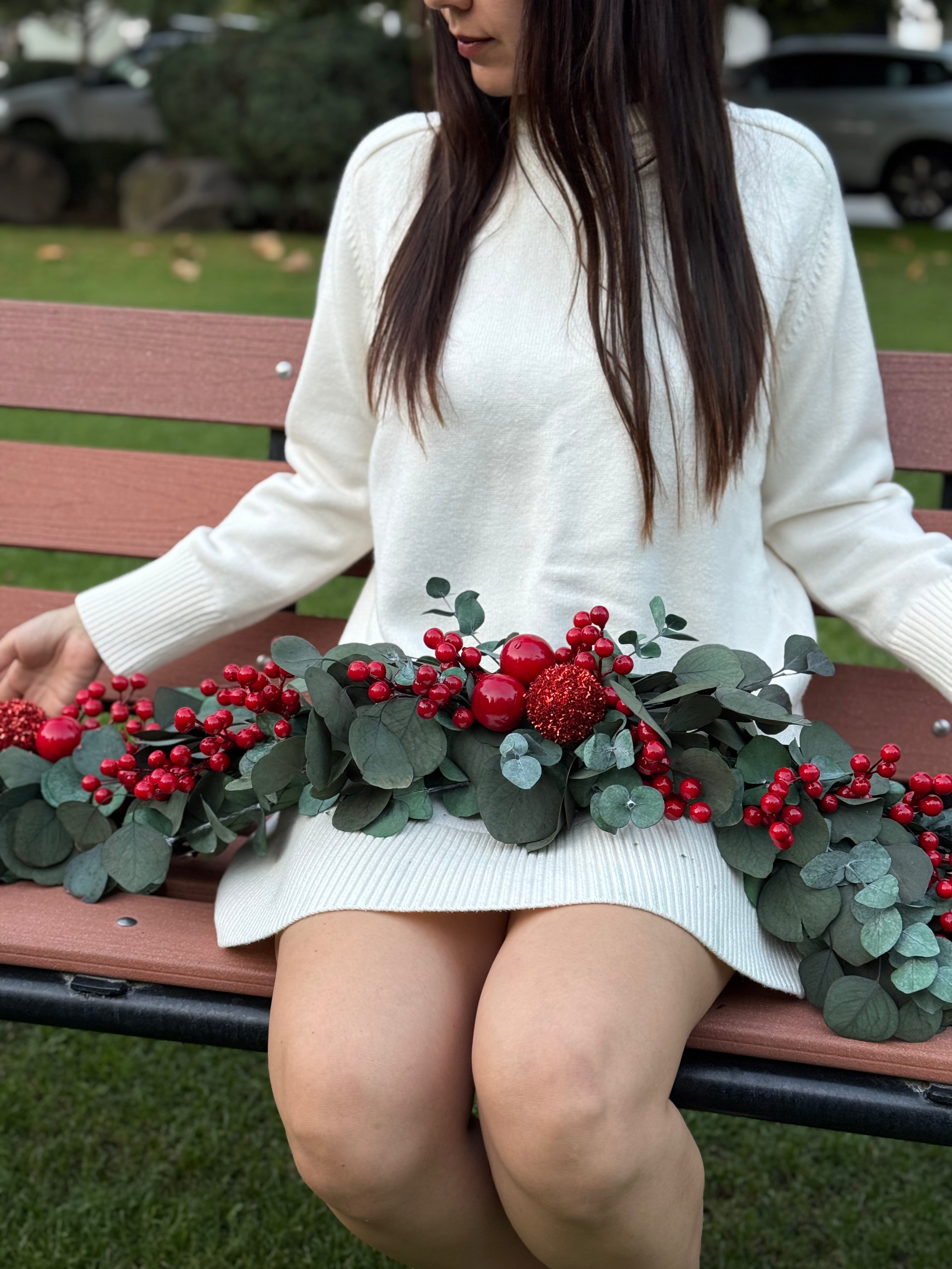 Decoración navideña con eucalipto silver, esferas brillantes rojas y cerezas.