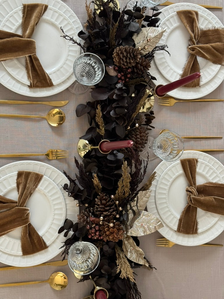 Camino de mesa Mocha de 120 cm con eucalipto café, piñas naturales y esferas doradas y bronce.
