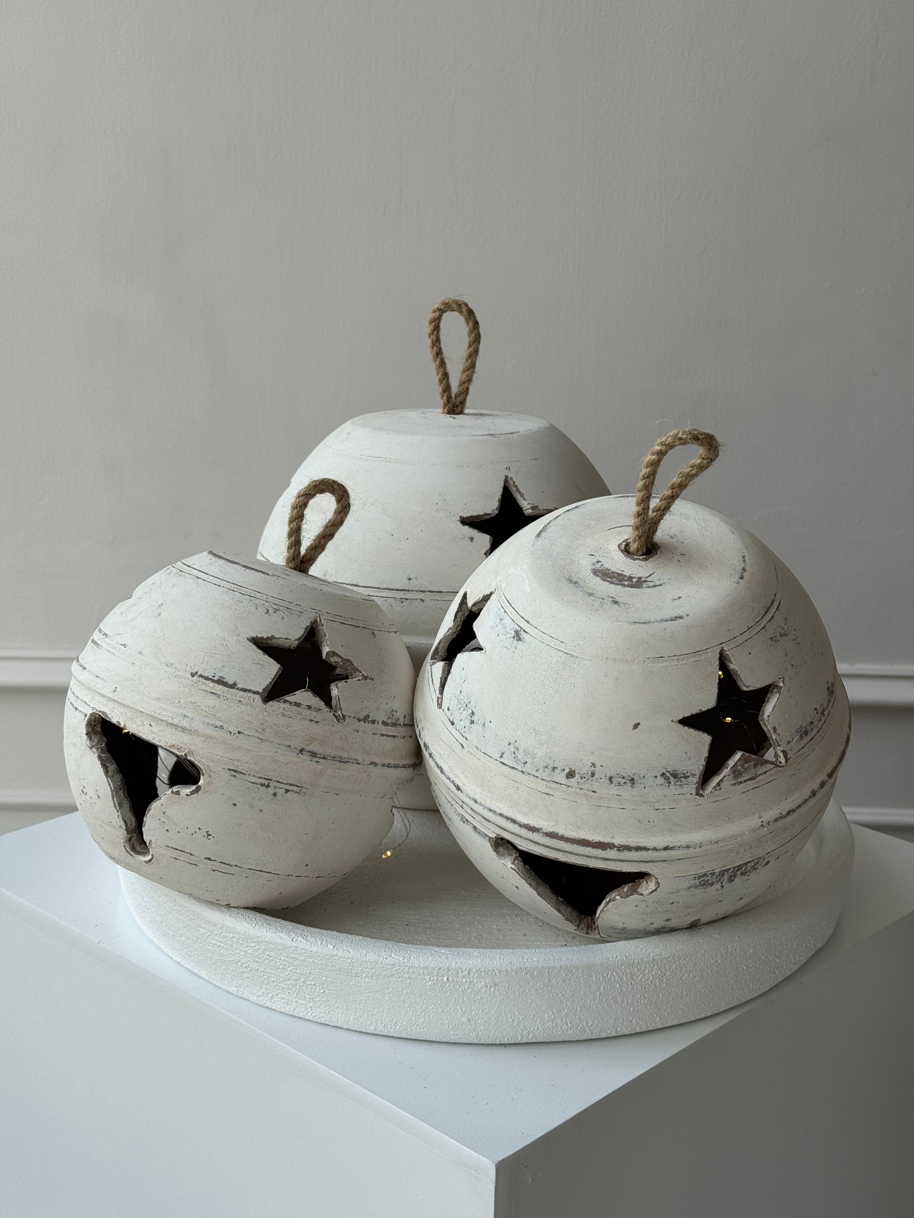 Juego de 3 cascabeles blancos de barro artesanal con luz LED interior, tamaños de 20, 24 y 28 cm.
