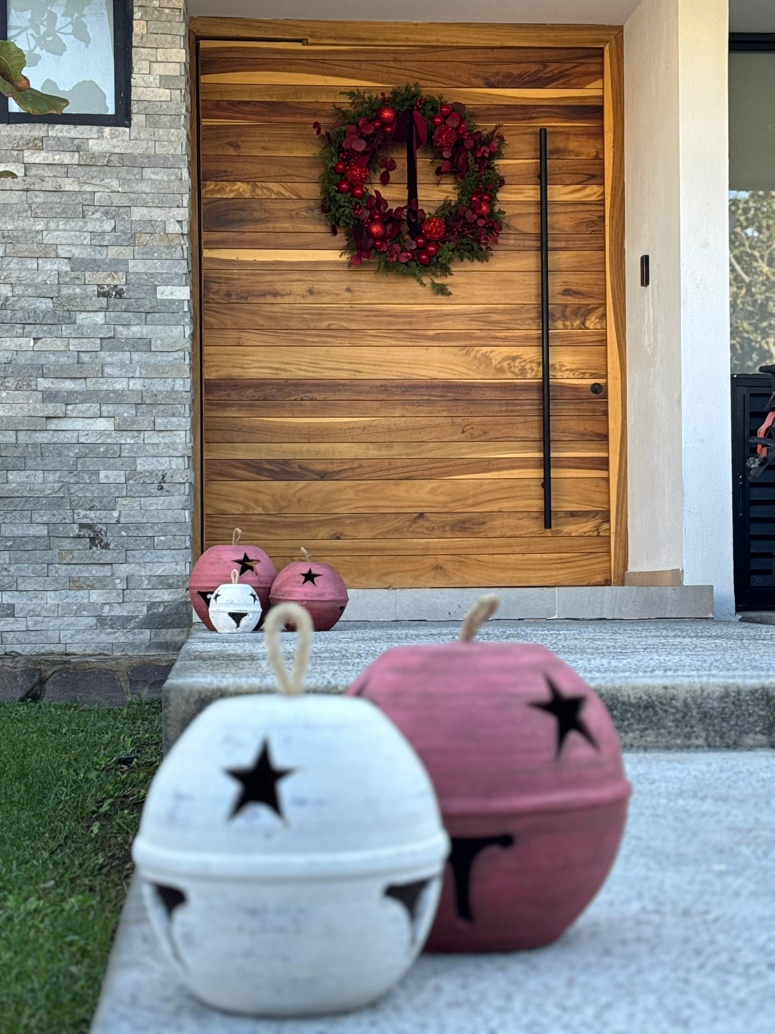 Par de cascabeles tintos en rojo terroso con luz LED integrada, tamaños 35 y 28 cm.
