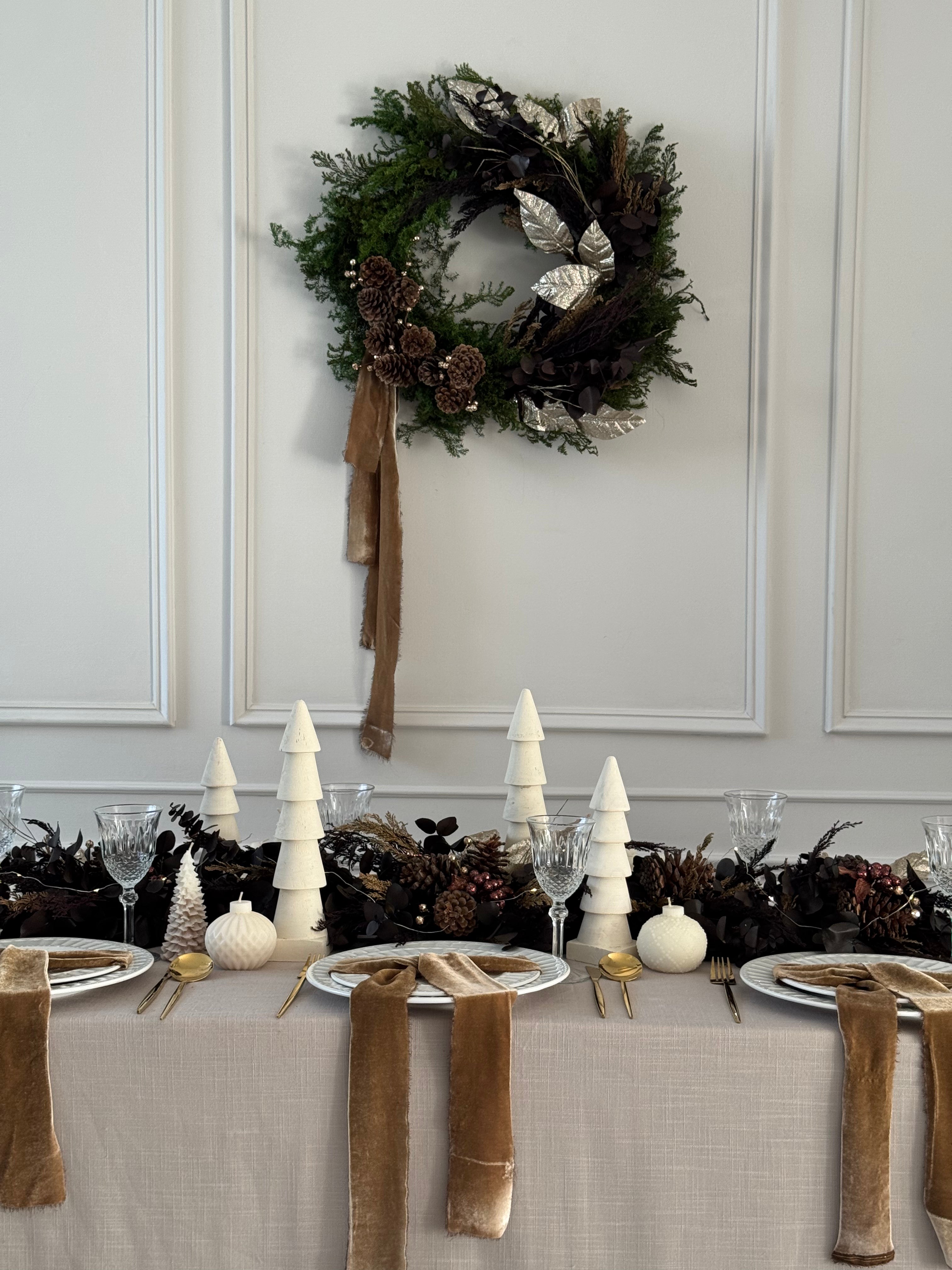 Corona de Navidad de 60 cm decorada con pino verde, hojas doradas, piñas naturales y listón de terciopelo dorado.