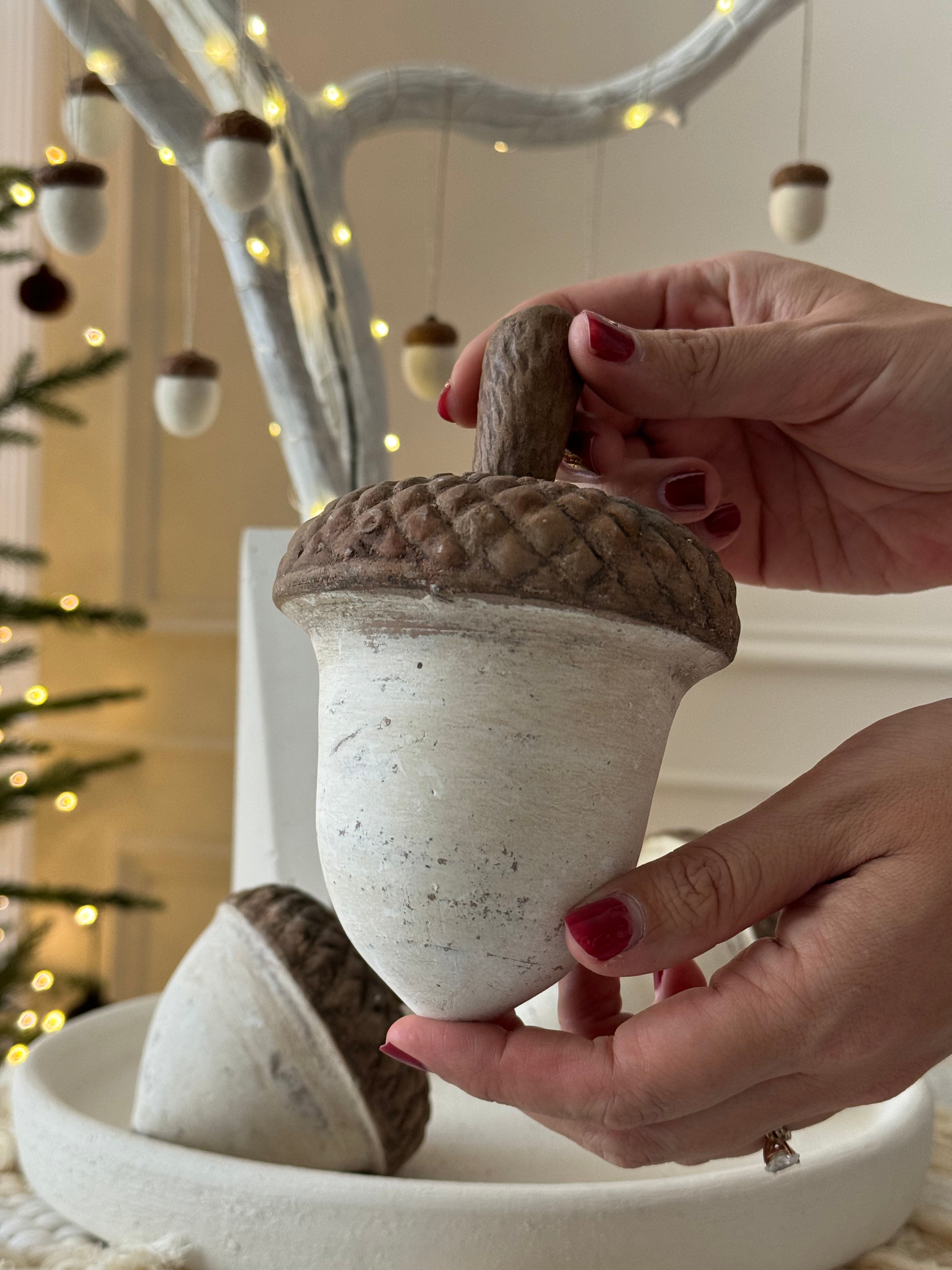 Set de tres bellotas de barro artesanal en tonos café y blanco, con diferentes formas y tamaños para decoración rústica y natural.
