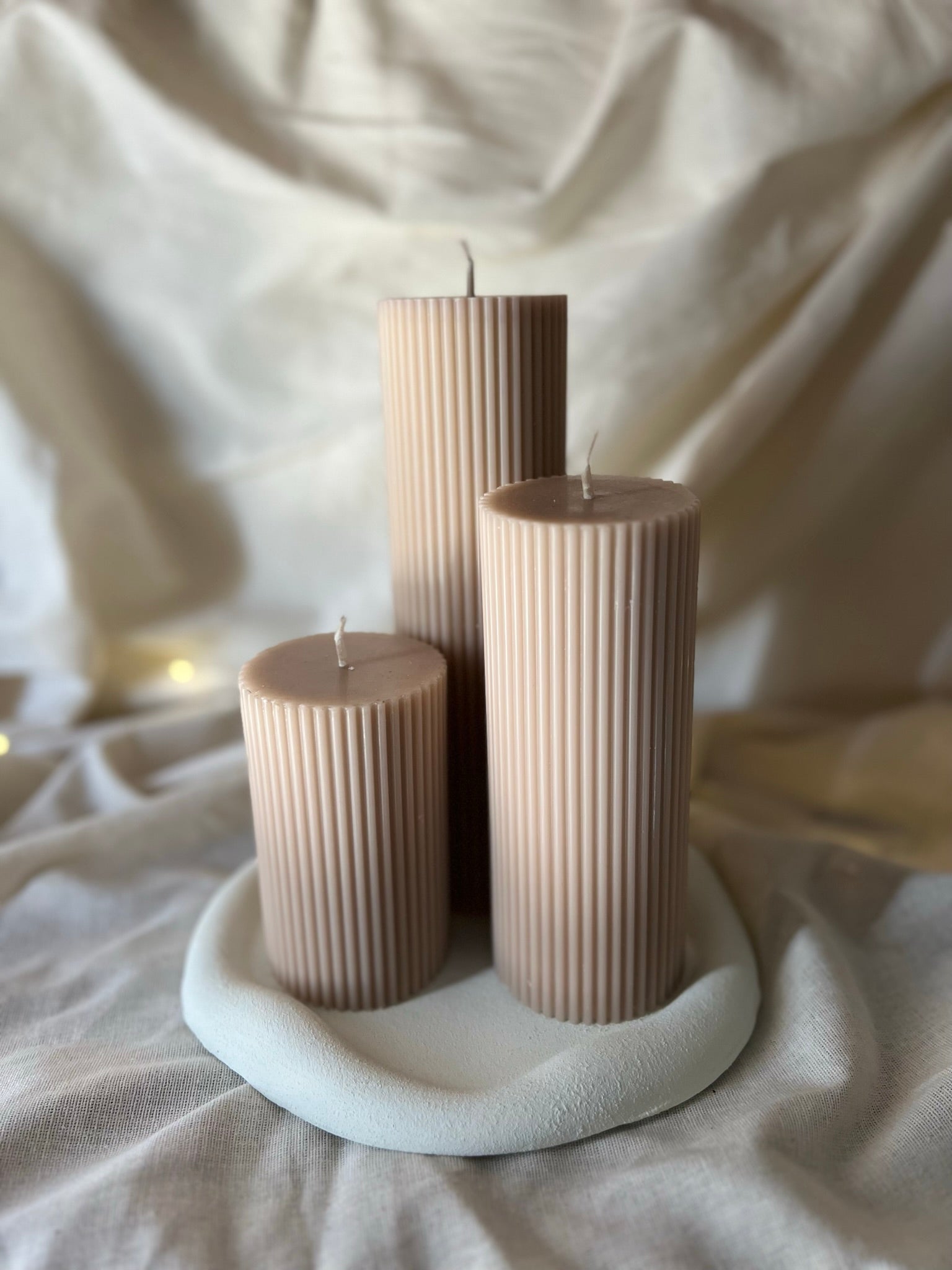 Set de tres velas tipo cirio en tono nude hechas de cera de soja artesanal, ideales para decoración cálida y minimalista.
