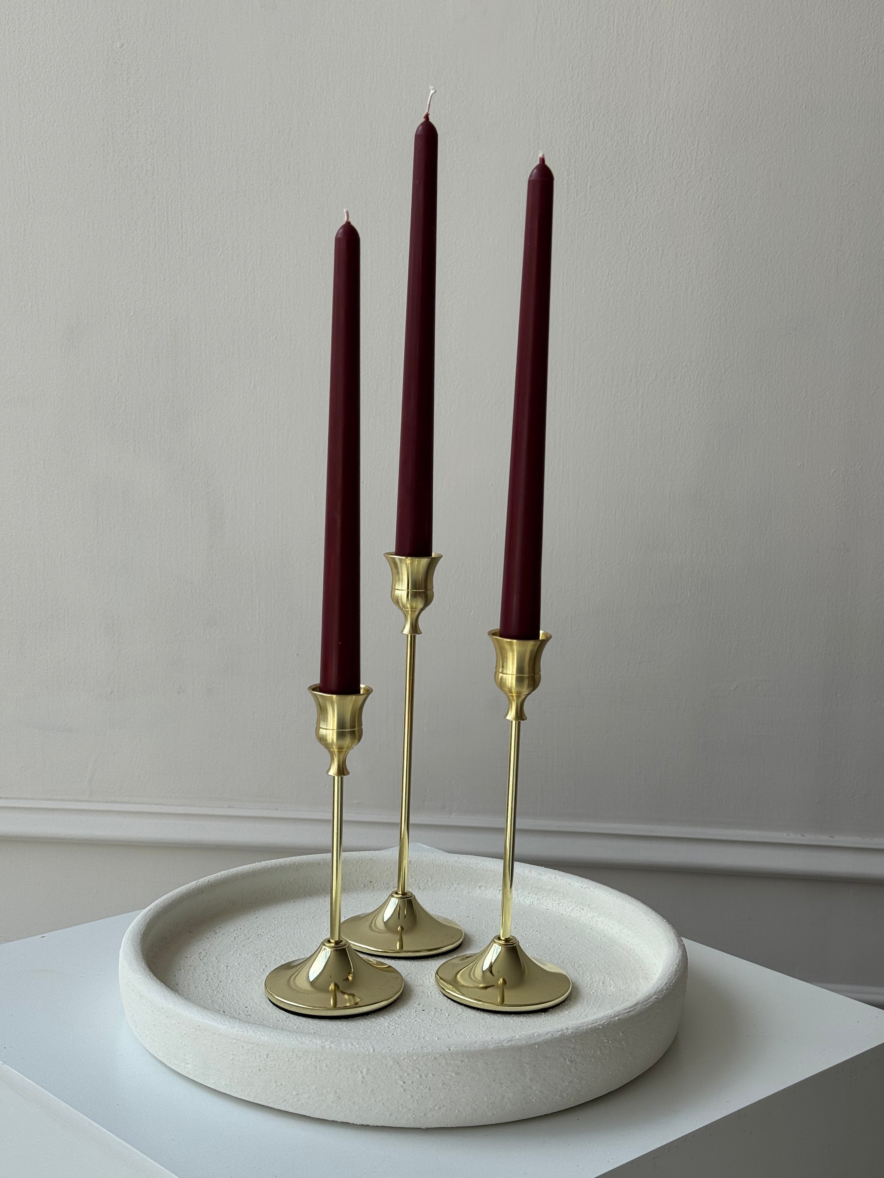 Candelabros dorados con velas tintas de cera de soja con aroma a canela, set de tres piezas altas.
